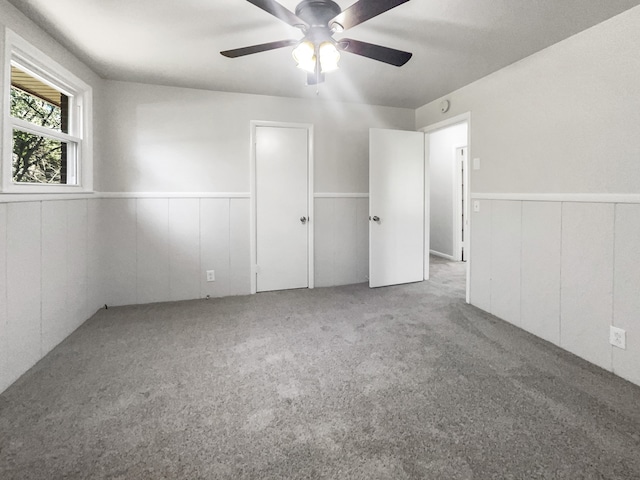 carpeted spare room featuring ceiling fan