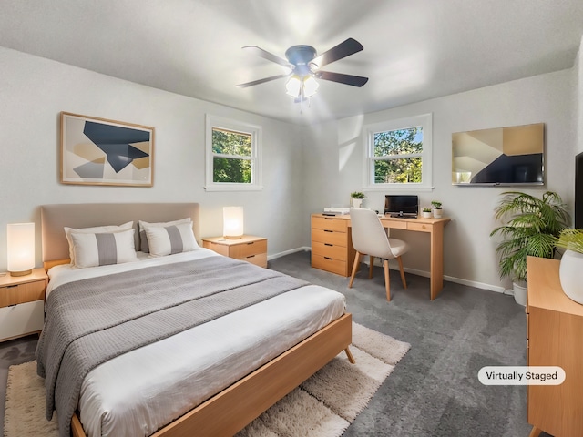 bedroom featuring ceiling fan, multiple windows, and dark carpet