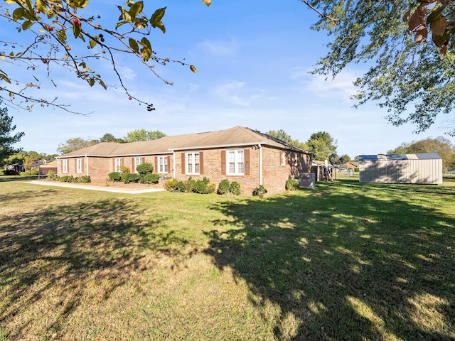 ranch-style house featuring an outdoor structure and a front lawn