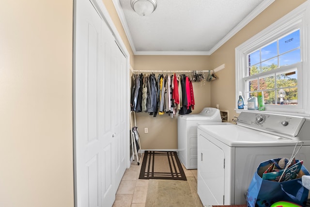 laundry area featuring light tile patterned floors, a textured ceiling, washing machine and dryer, and ornamental molding