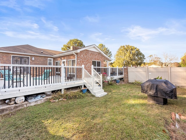 rear view of property featuring a yard and a wooden deck