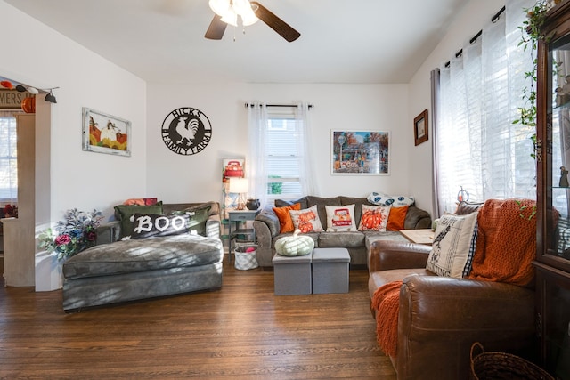 living room featuring dark wood-type flooring and ceiling fan