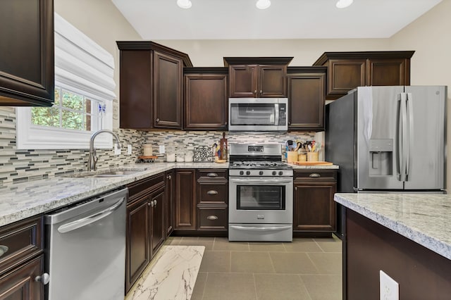 kitchen featuring sink, appliances with stainless steel finishes, dark brown cabinets, and backsplash