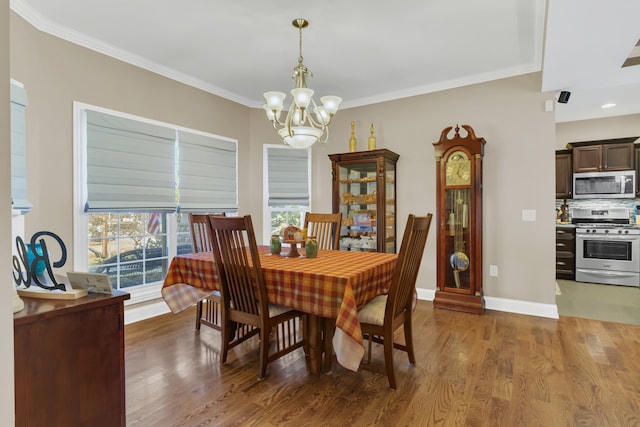 dining space with crown molding, a chandelier, and wood-type flooring