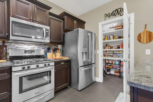 kitchen with decorative backsplash, appliances with stainless steel finishes, dark brown cabinetry, and light tile patterned floors