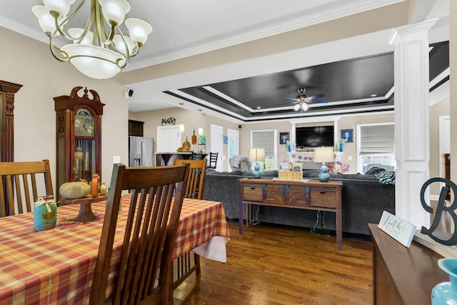 dining room featuring plenty of natural light, a raised ceiling, ornamental molding, and dark hardwood / wood-style flooring