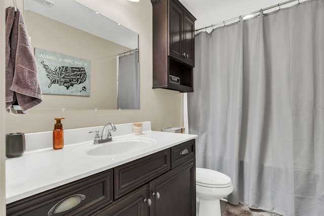 bathroom featuring vanity, walk in shower, and toilet