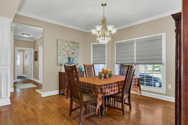 dining area with crown molding, a notable chandelier, and hardwood / wood-style flooring