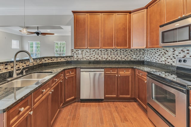 kitchen featuring appliances with stainless steel finishes, light hardwood / wood-style flooring, sink, and backsplash