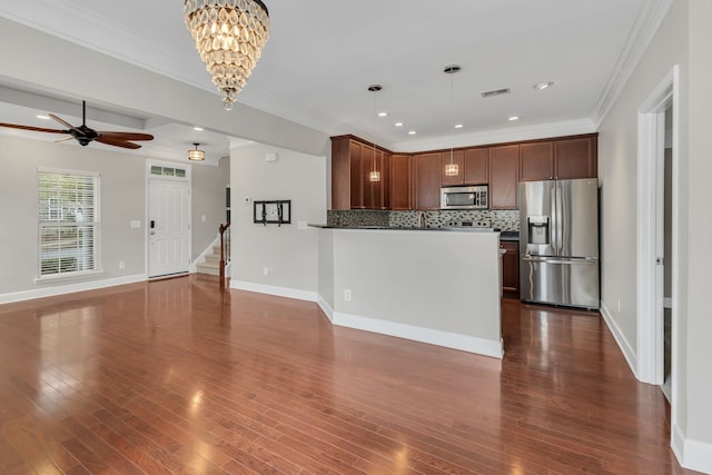 kitchen with tasteful backsplash, dark hardwood / wood-style flooring, stainless steel appliances, decorative light fixtures, and crown molding