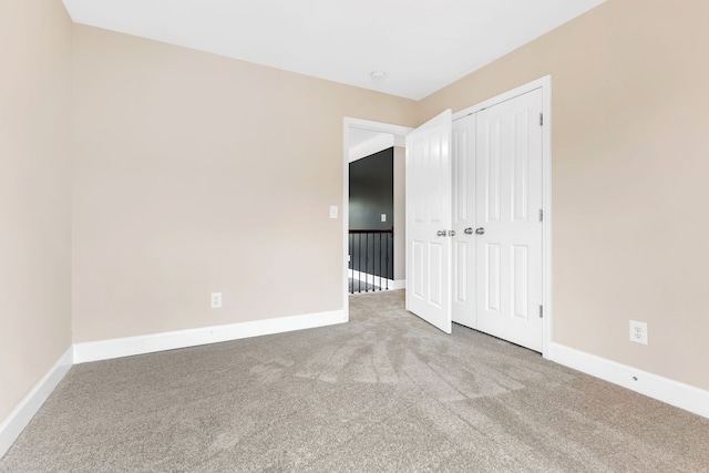 unfurnished bedroom with light carpet and a closet