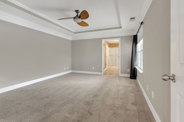 carpeted empty room with ceiling fan, ornamental molding, and a tray ceiling