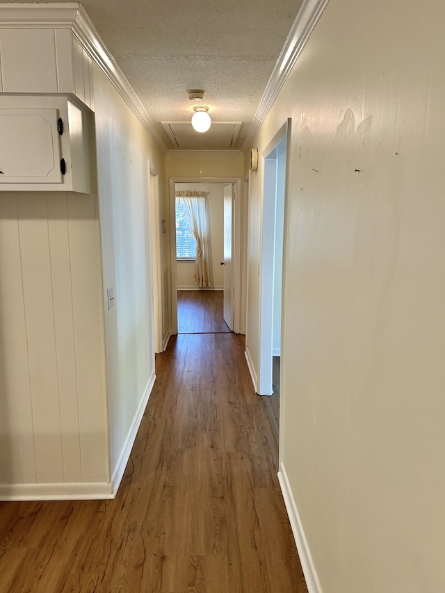 hallway with ornamental molding, a textured ceiling, and dark hardwood / wood-style floors