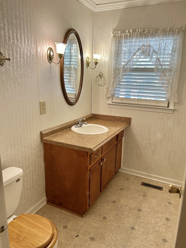 bathroom featuring vanity, toilet, and crown molding