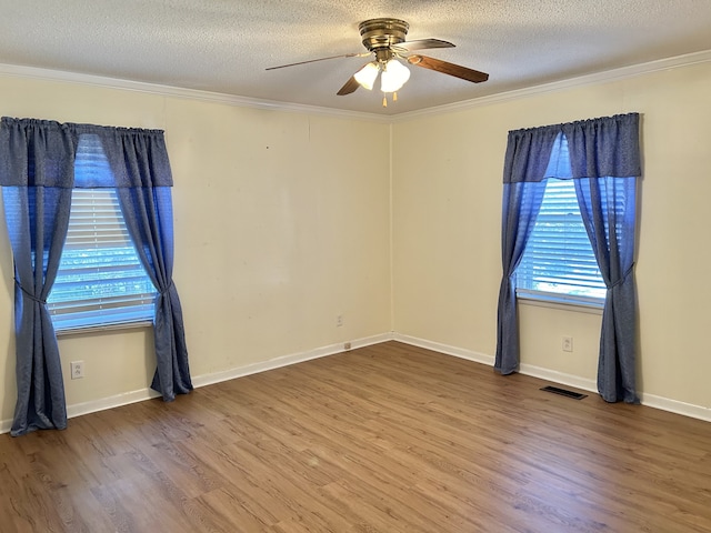 spare room featuring ornamental molding, hardwood / wood-style floors, and a textured ceiling