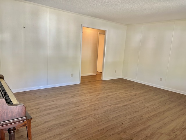 spare room with a textured ceiling and hardwood / wood-style flooring