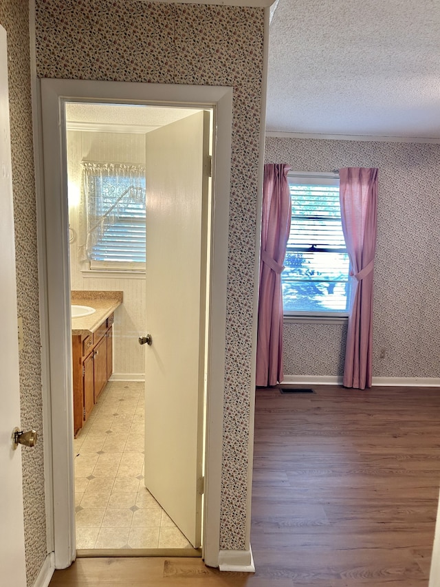 corridor featuring light hardwood / wood-style floors and a textured ceiling