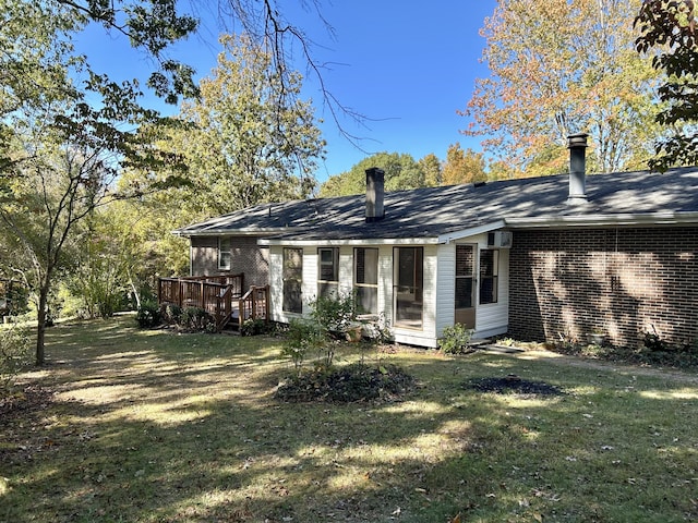 back of property featuring a wooden deck and a lawn