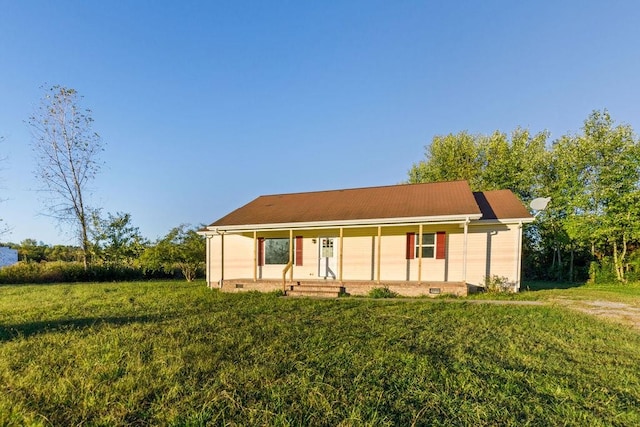 back of house with covered porch and a lawn