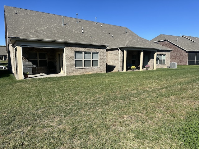 back of house featuring a lawn and central AC unit