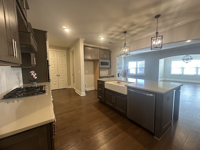 kitchen featuring sink, hanging light fixtures, dark hardwood / wood-style flooring, a kitchen island with sink, and appliances with stainless steel finishes