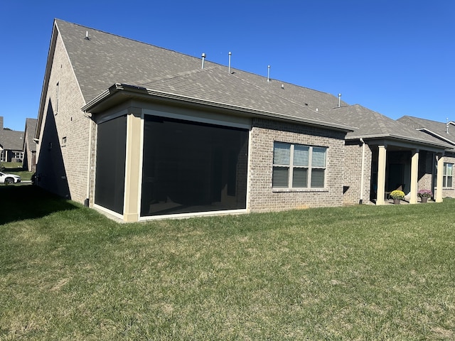 rear view of property featuring a lawn