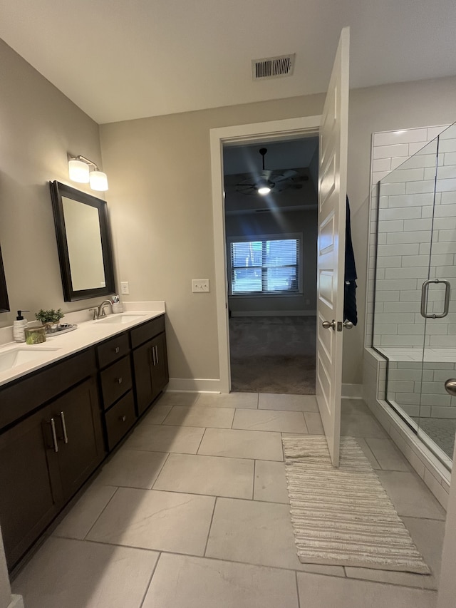 bathroom featuring tile patterned floors, a shower with door, and vanity