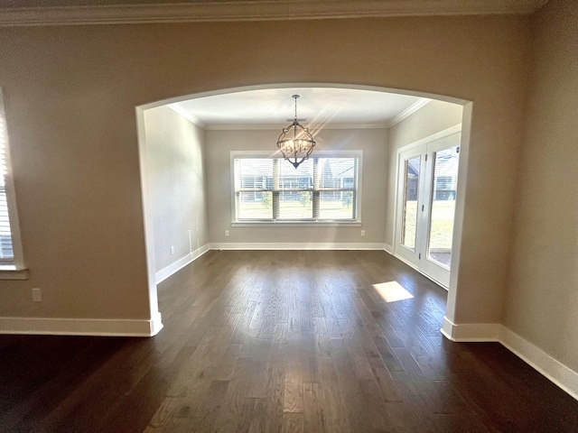 unfurnished dining area with dark hardwood / wood-style floors, crown molding, and a notable chandelier