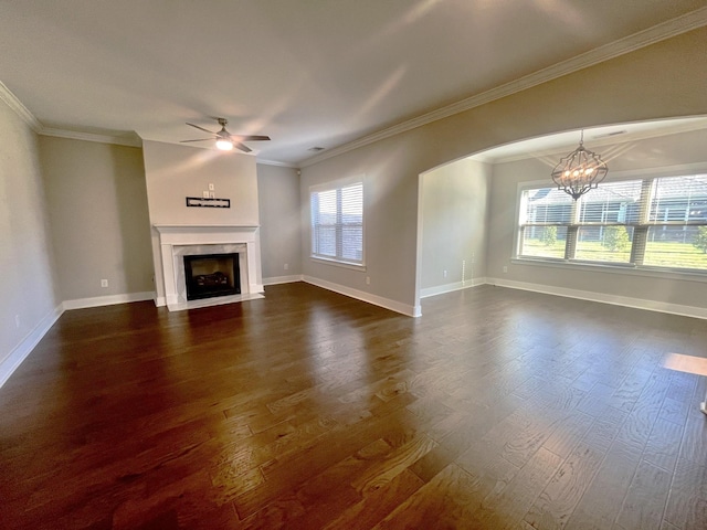 unfurnished living room with a fireplace with flush hearth, ornamental molding, dark wood-type flooring, and ceiling fan with notable chandelier