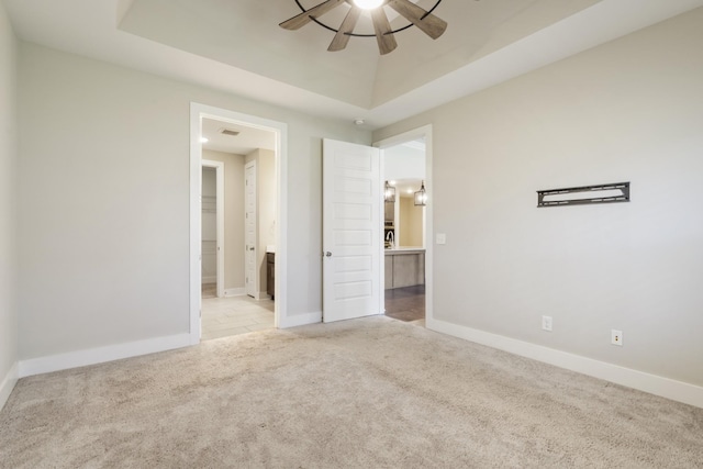 1509 Cedarbrooke Ln, Lebanon, TN 37090 - unfurnished bedroom featuring carpet flooring, a tray ceiling, ensuite bath, and a ceiling fan