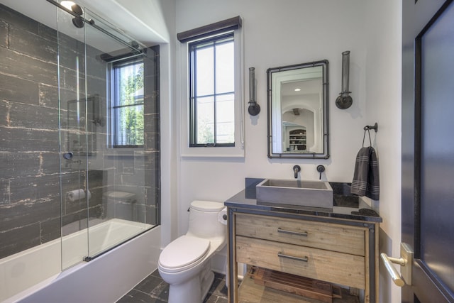 full bathroom featuring toilet, enclosed tub / shower combo, and vanity