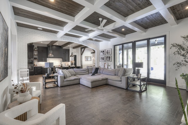 living room with beam ceiling, sink, coffered ceiling, and dark hardwood / wood-style flooring