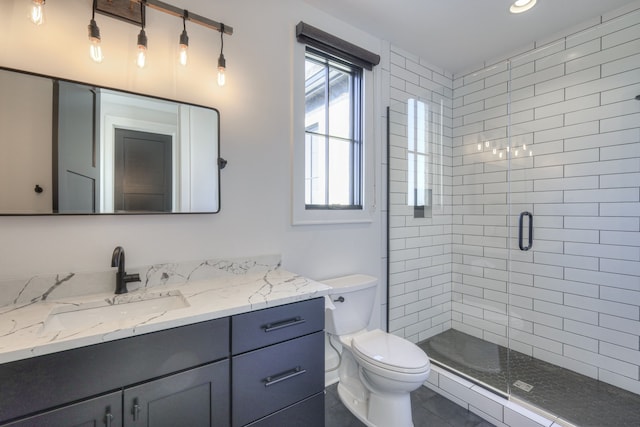 bathroom featuring a shower with door, vanity, toilet, and tile patterned floors