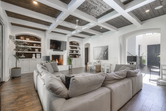 living room featuring dark hardwood / wood-style floors, beam ceiling, coffered ceiling, and built in features