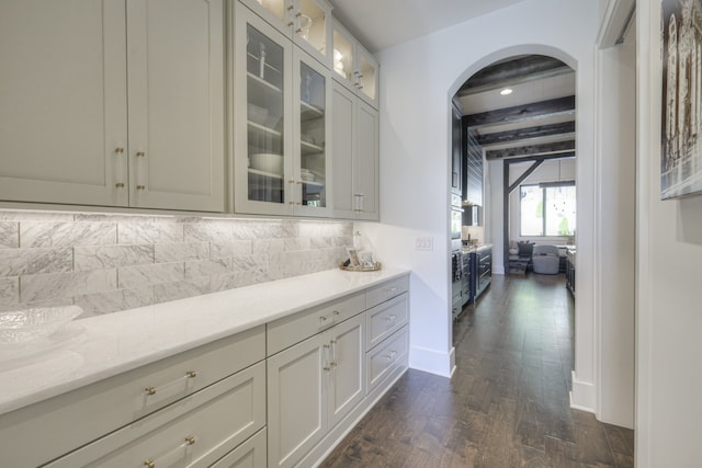 bar featuring beam ceiling, tasteful backsplash, dark hardwood / wood-style flooring, and light stone counters