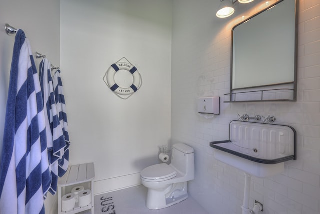 bathroom featuring toilet, tile patterned floors, and tile walls