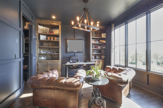 living room with a notable chandelier, built in shelves, and dark hardwood / wood-style flooring