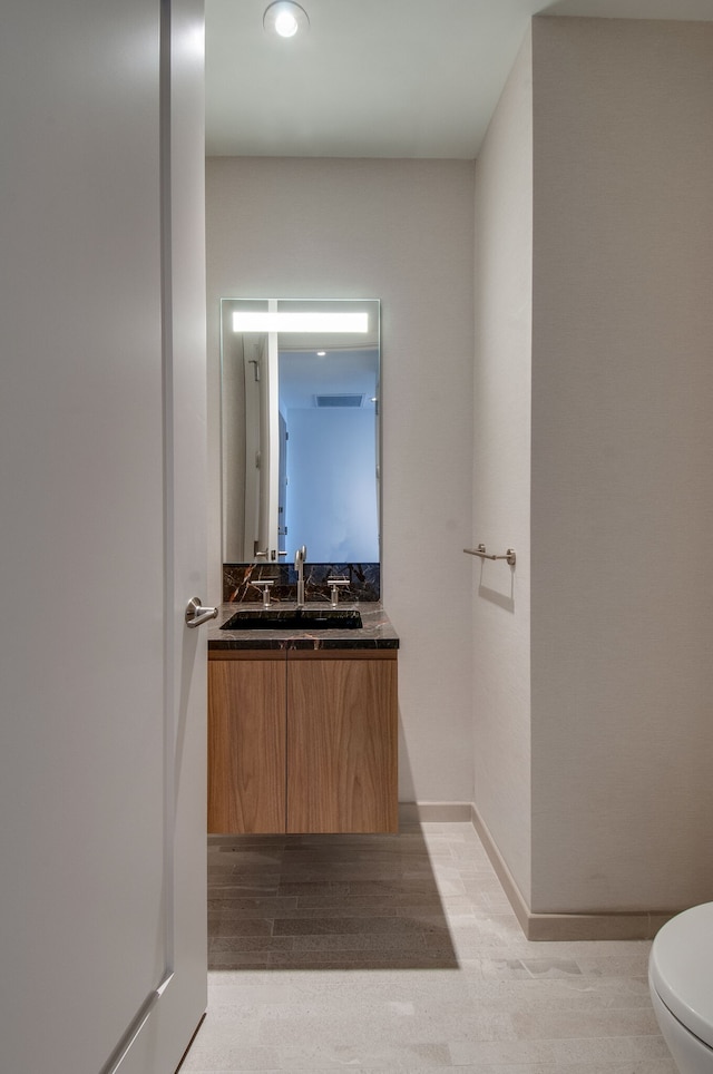 bathroom featuring vanity, hardwood / wood-style flooring, and toilet