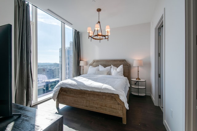 bedroom featuring an inviting chandelier and dark hardwood / wood-style flooring