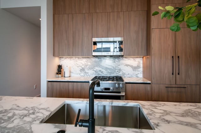 kitchen with sink, decorative backsplash, and appliances with stainless steel finishes