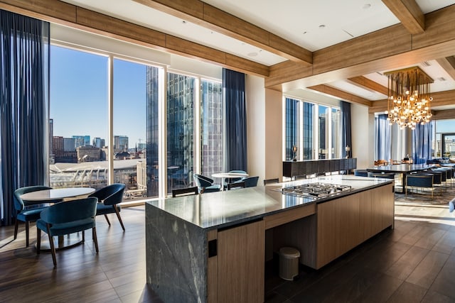 kitchen featuring dark wood-type flooring, stainless steel gas cooktop, decorative light fixtures, and an inviting chandelier