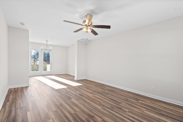 empty room with french doors, ceiling fan with notable chandelier, and dark wood-type flooring