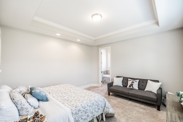 bedroom featuring a tray ceiling, connected bathroom, and light carpet