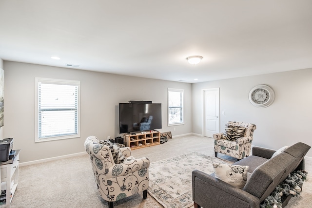 living room featuring a wealth of natural light and light colored carpet