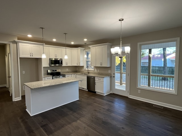 kitchen featuring pendant lighting, a center island, sink, appliances with stainless steel finishes, and white cabinetry