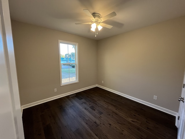 empty room with dark hardwood / wood-style flooring and ceiling fan