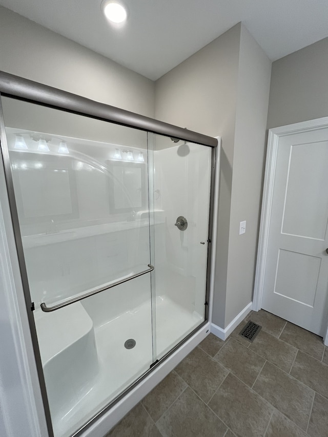 bathroom with a shower with door