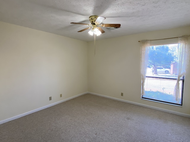 carpeted spare room featuring ceiling fan and a textured ceiling