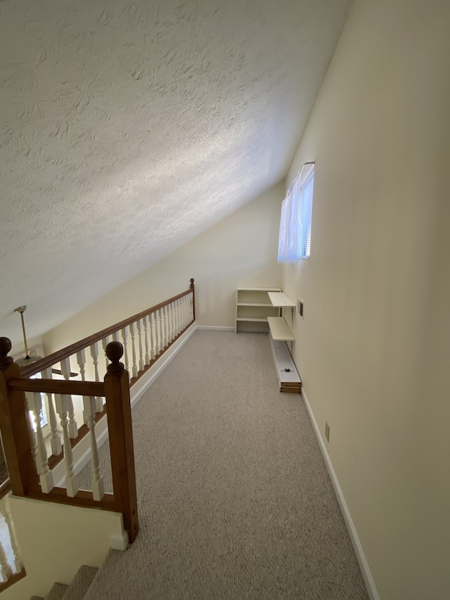 bonus room with a textured ceiling, carpet floors, and vaulted ceiling