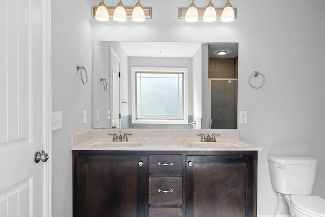 bathroom featuring vanity, a shower with shower door, and toilet